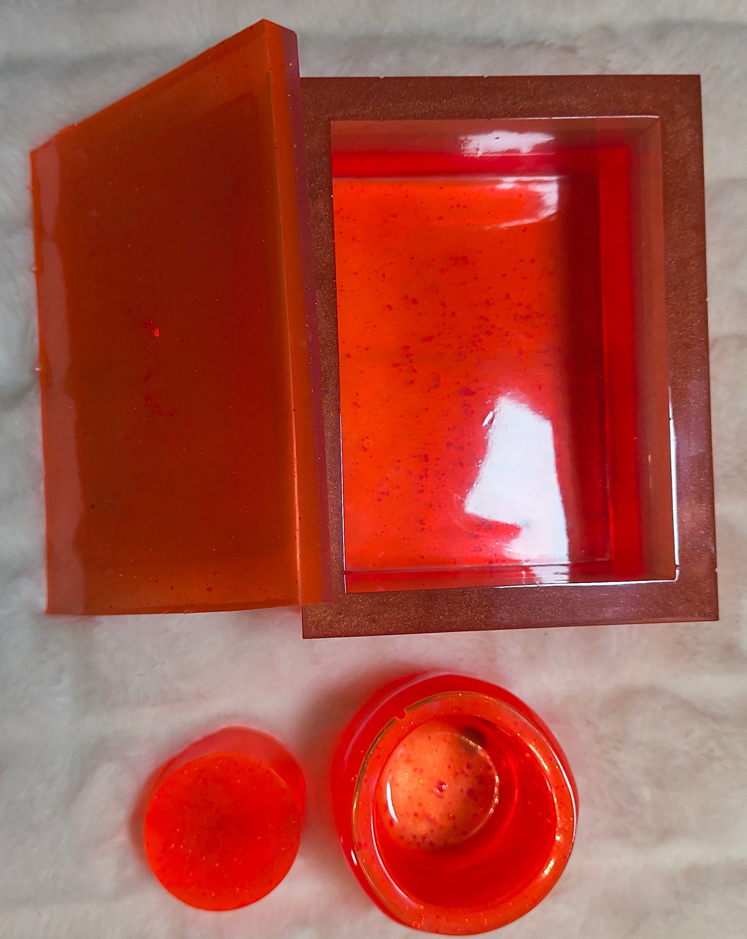 Small little jug with stopper and a larger trinket holder with lid both in a florescent  neon orange and creamy white. Both resin