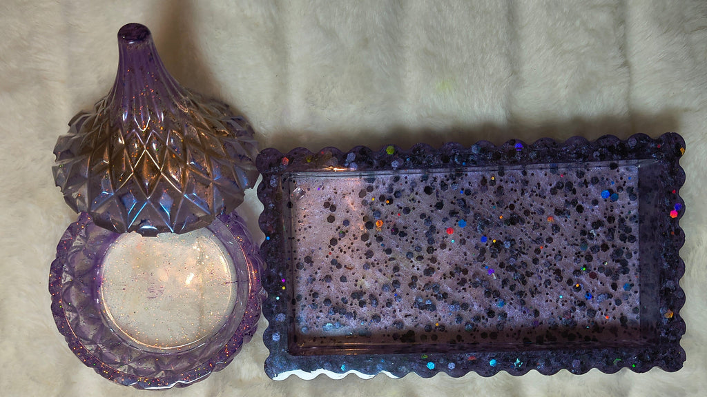 Photo of holder set, one tray in hues of purples with sparkles. Then a little container  with a beautiful lid with purple hues, browns, and sparkles.