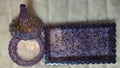 Photo of holder set, one tray in hues of purples with sparkles. Then a little container  with a beautiful lid with purple hues, browns, and sparkles.