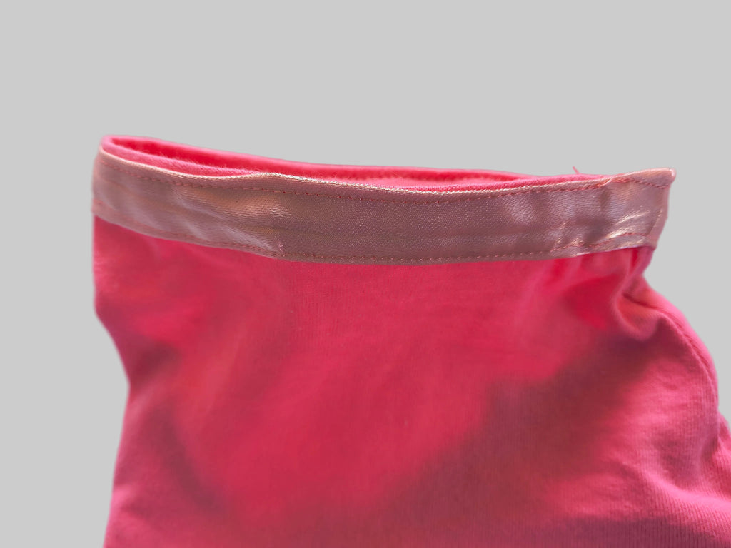 Close-up of a pink satin trim around sleeves and bottom of the T-shit
