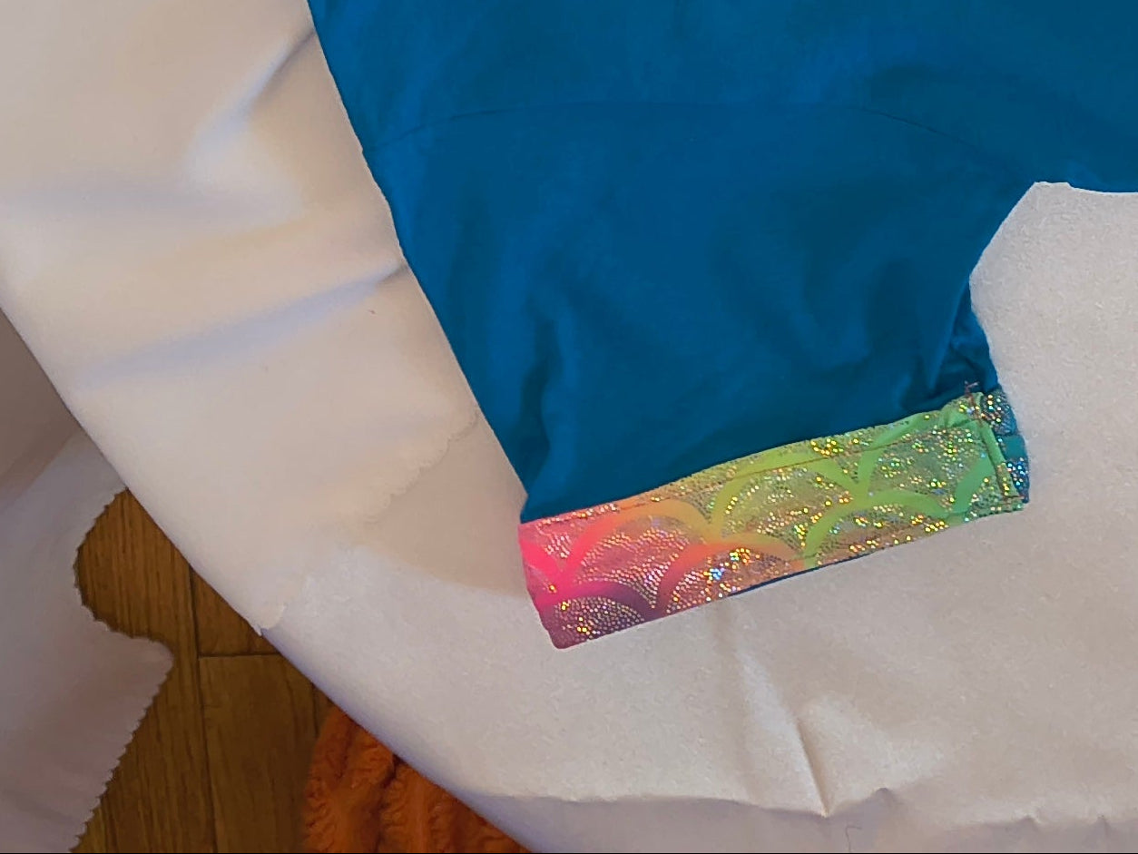 Short Sleeve T-Shirt, Turquise, 100% cotton. Unicorns and Butterfly graphic with a multicolor fabric trim that sparkles around sleeves and bottom of shirt