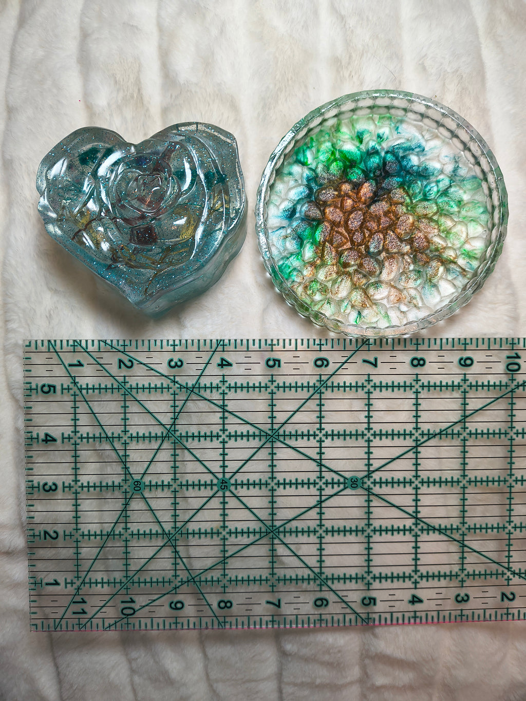 Handcrafted clear heart with little buttons an resin trinket holder set of 2 shown in hand flowers added to the resin. Then a multicolor tray with ruler to get idea of size