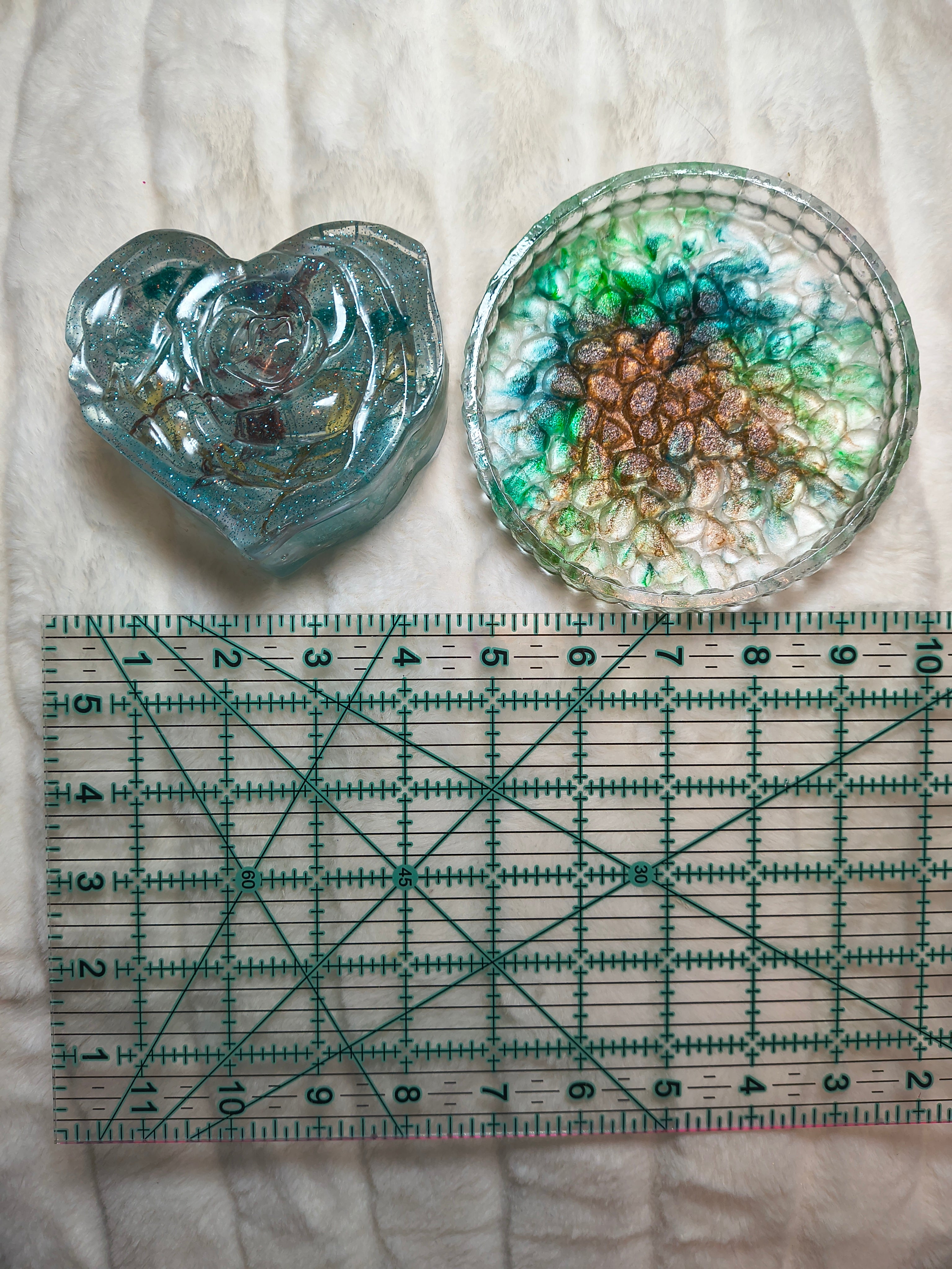 Handcrafted clear heart with little buttons an resin trinket holder set of 2 shown in hand flowers added to the resin. Then a multicolor tray with ruler to get idea of size